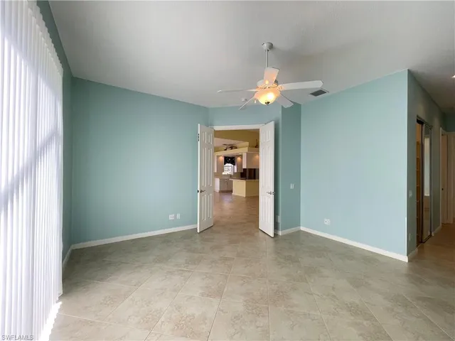 an empty room with closet and a chandelier fan