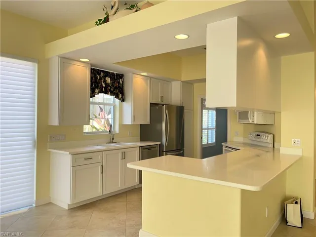 a kitchen with stainless steel appliances a refrigerator sink and stove