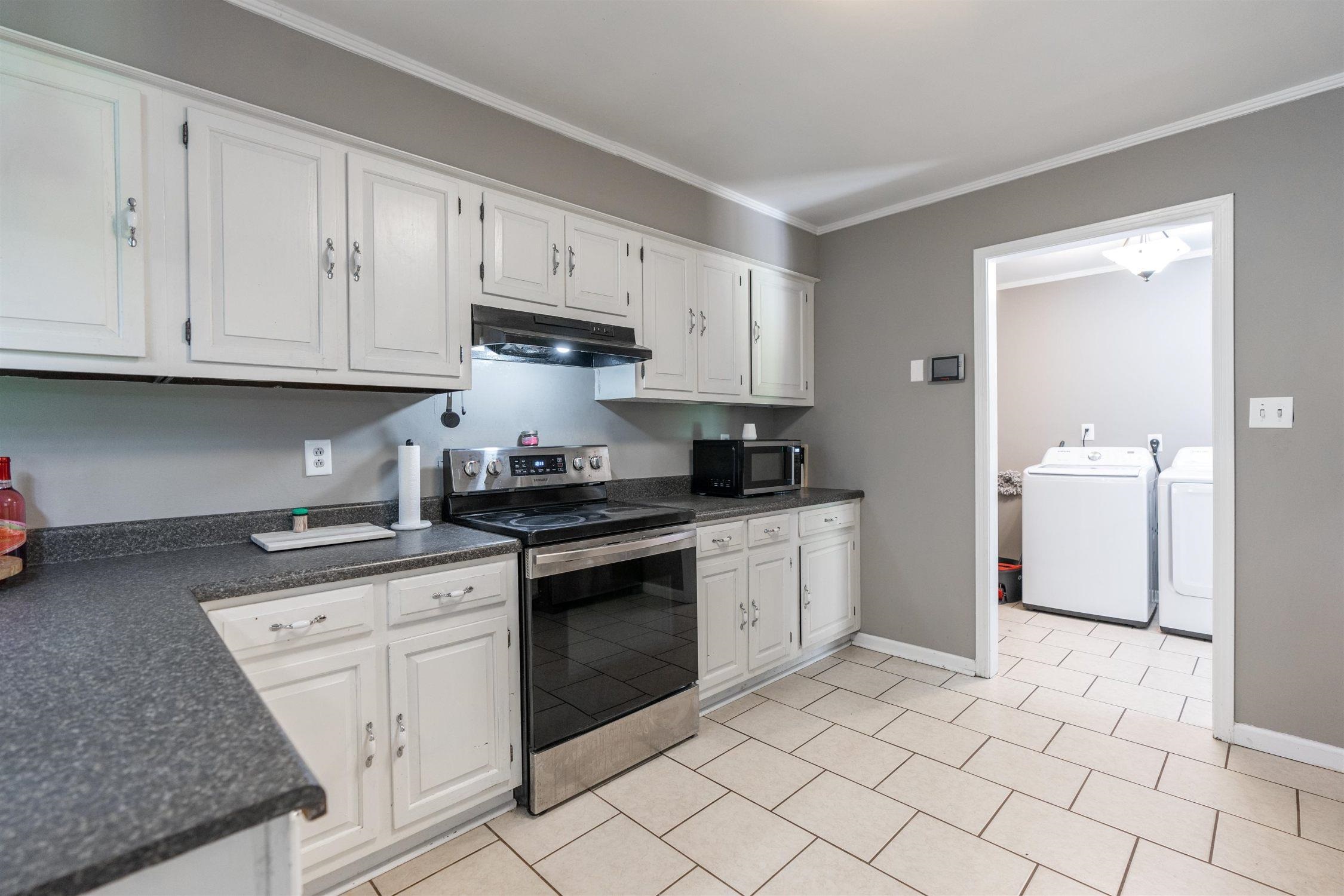 332 Waits Road Burlison, TN 38015 - Photo 2 of 11 a kitchen with granite countertop a stove sink and cabinets
