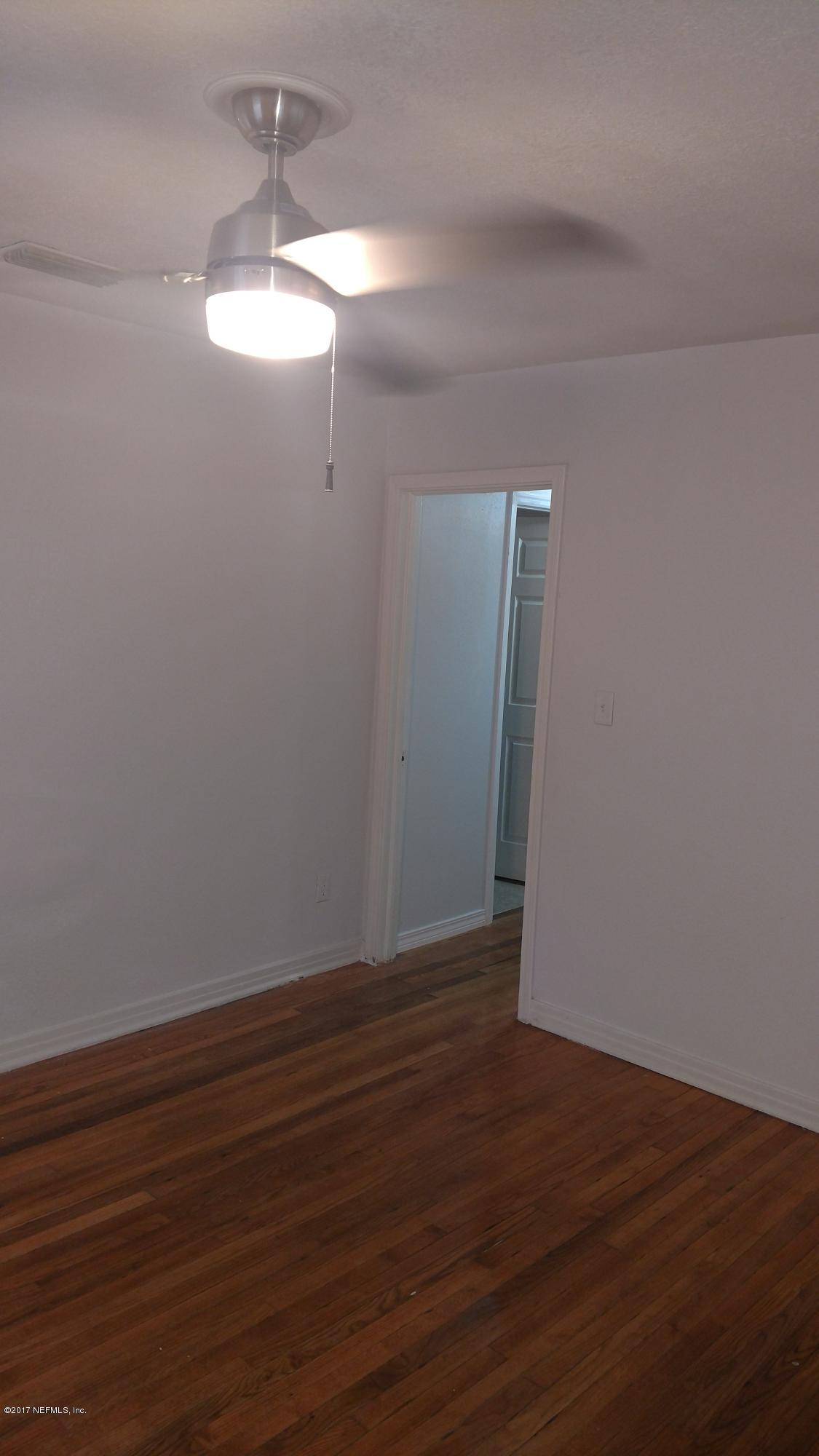 10533 Arendal Road Jacksonville, FL 32218 - Photo 7 of 11 a view of an empty room with wooden floor and a window