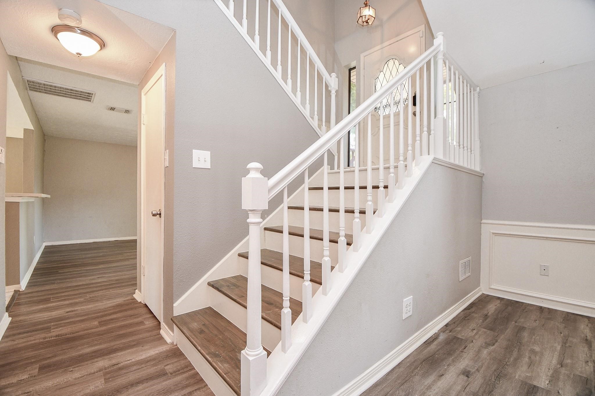 2331 Wren Meadow Road Richmond, TX 77406 - Photo 3 of 37 The central staircase features modern railings and leads to both the upper and lower levels, showcasing the home's split level design!