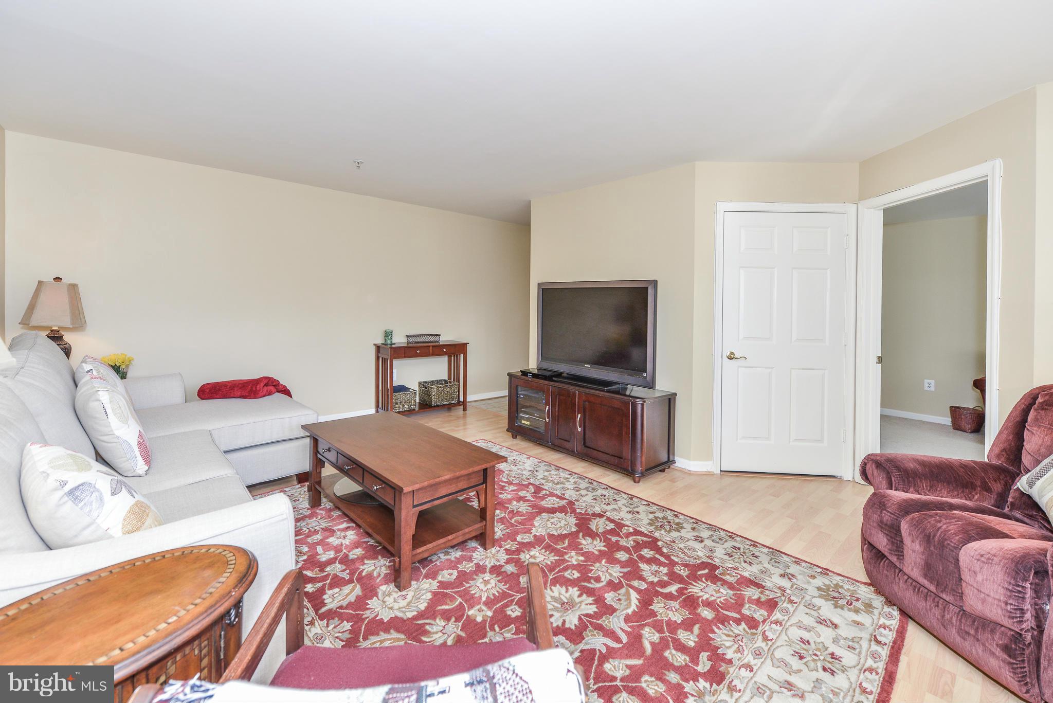 511 Constellation Square Southeast, Unit A Leesburg, VA 20175 - Photo 24 of 27 a living room with furniture and a flat screen tv
