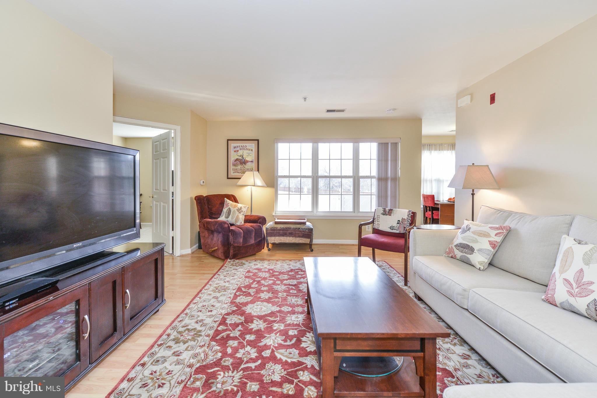 511 Constellation Square Southeast, Unit A Leesburg, VA 20175 - Photo 25 of 27 a living room with furniture and a flat screen tv