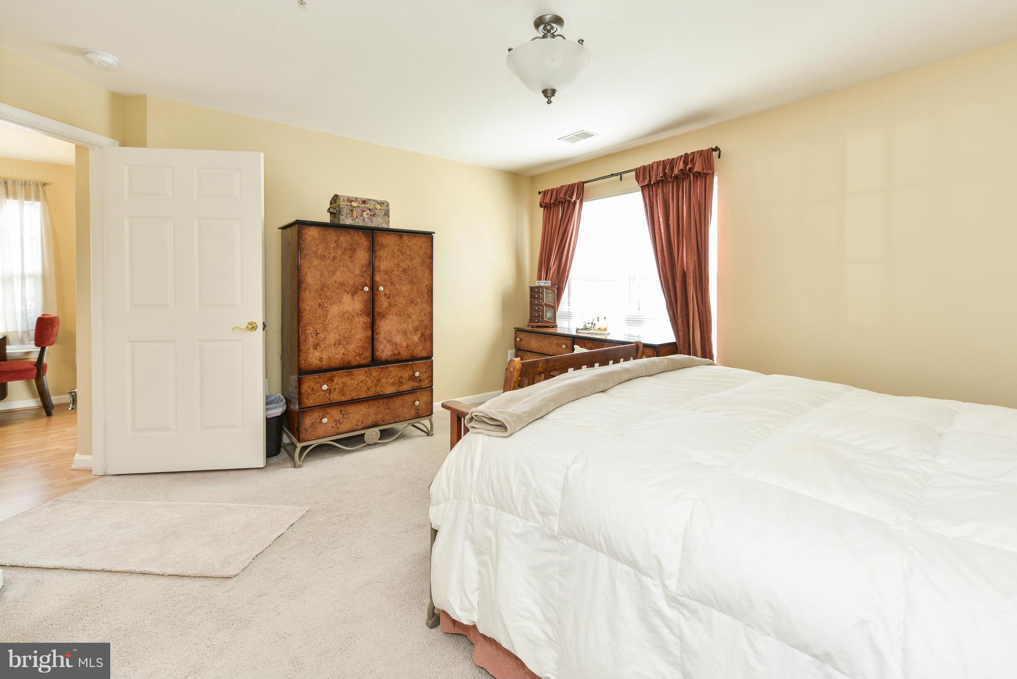 511 Constellation Square Southeast, Unit A Leesburg, VA 20175 - Photo 26 of 27 a spacious bedroom with a bed and a window
