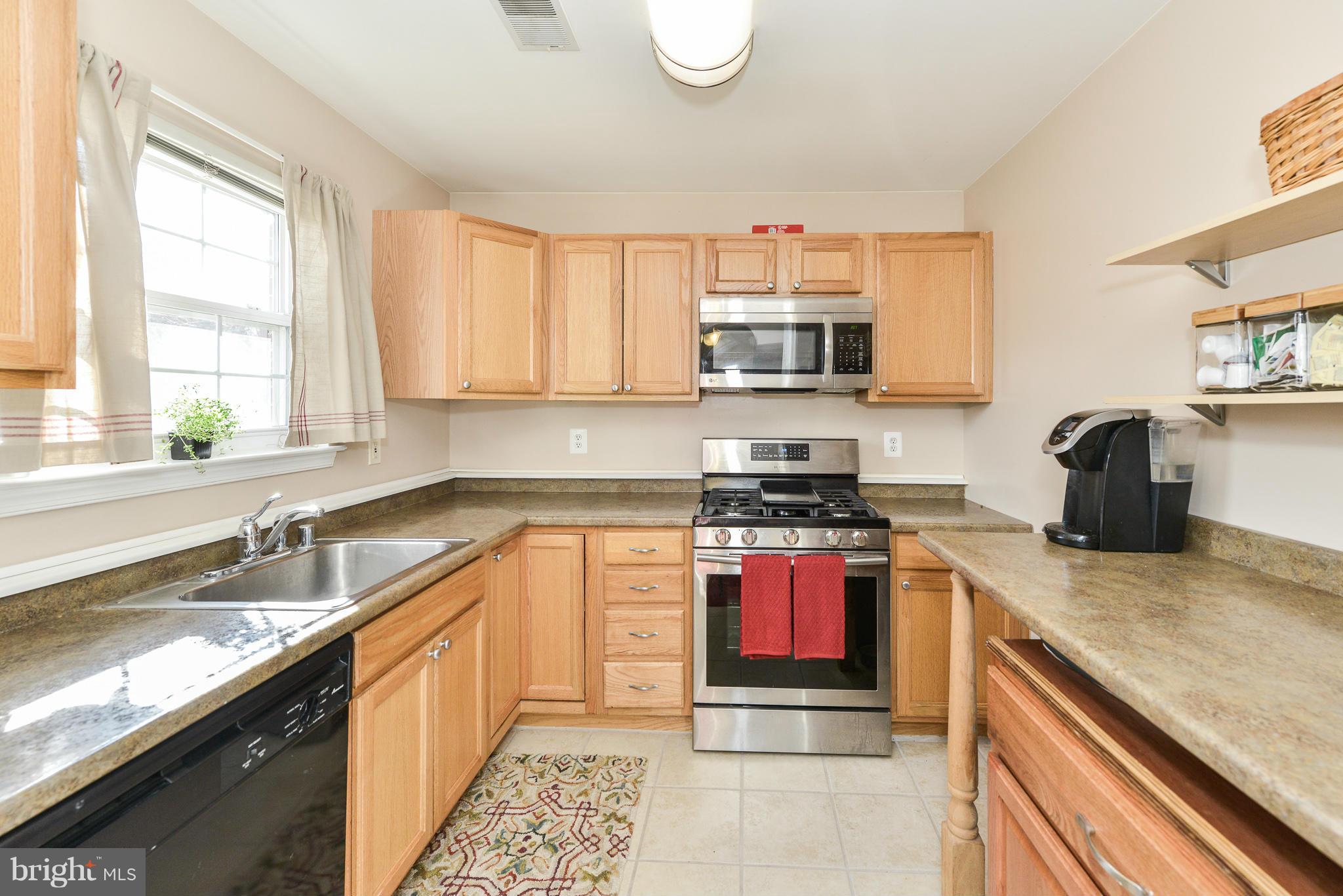 511 Constellation Square Southeast, Unit A Leesburg, VA 20175 - Photo 7 of 27 a kitchen with stainless steel appliances granite countertop a sink stove and microwave