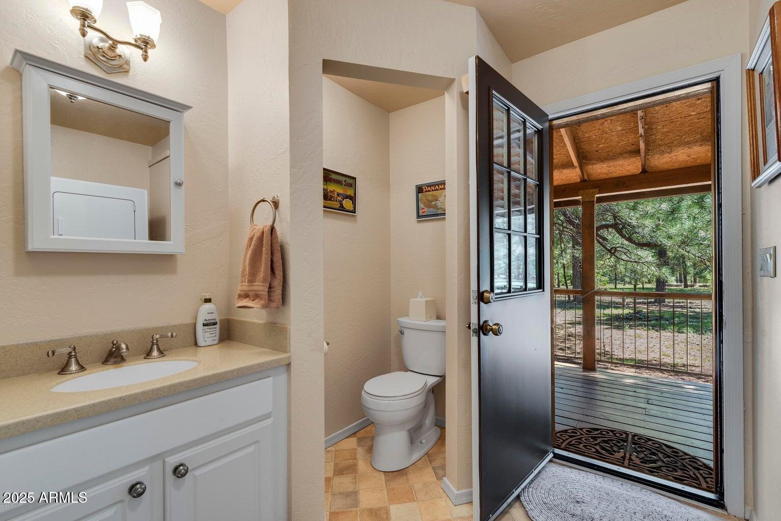 207 Blue Ridge Road Mormon Lake, AZ 86038 - Photo 32 of 66 a bathroom with a granite countertop sink toilet and mirror