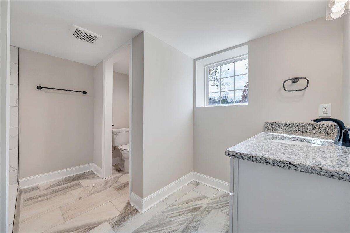 149 Windlass Road Moneta, VA 24121 - Photo 30 of 44 a bathroom with a granite countertop sink and a mirror
