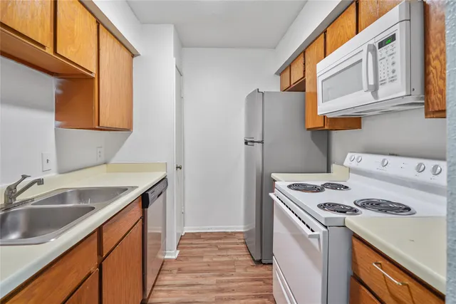a kitchen with a sink a stove and a refrigerator