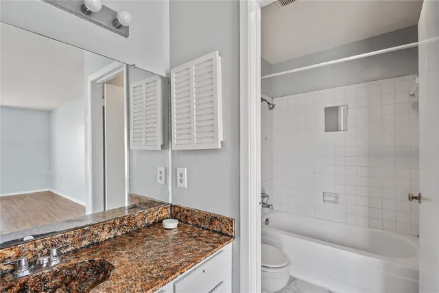 a bathroom with a granite countertop sink and toilet