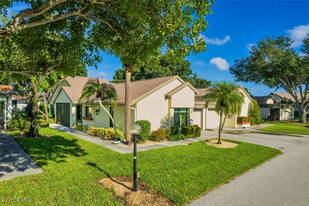 1683 Bent Tree Circle Fort Myers, FL 33907 - Photo 1 of 48 a view of a white house with a big yard and potted plants and large trees