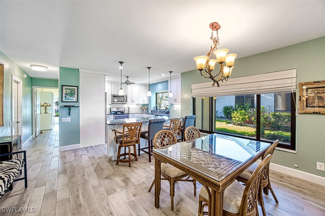 1683 Bent Tree Circle Fort Myers, FL 33907 - Photo 13 of 48 a dining room with furniture a chandelier and wooden floor