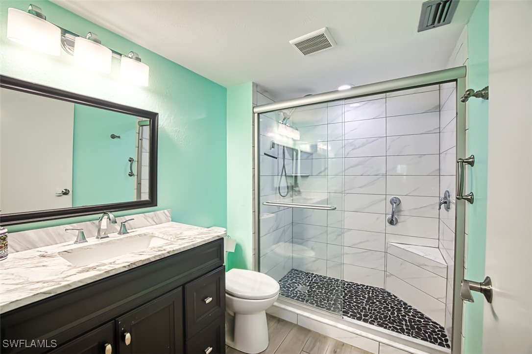 1683 Bent Tree Circle Fort Myers, FL 33907 - Photo 26 of 48 a bathroom with a granite countertop sink toilet and shower