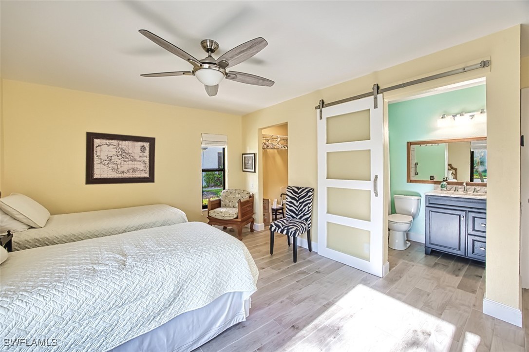 1683 Bent Tree Circle Fort Myers, FL 33907 - Photo 31 of 48 a bedroom with a bed and dresser with wooden floor