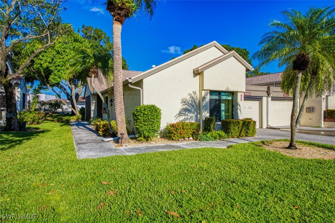 1683 Bent Tree Circle Fort Myers, FL 33907 - Photo 48 of 48 a front view of a house with a yard and palm trees