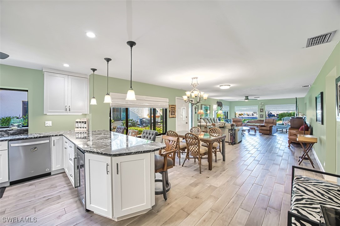 1683 Bent Tree Circle Fort Myers, FL 33907 - Photo 10 of 48 a dining hall with stainless steel appliances granite countertop a stove oven and a view of dining hall with couches