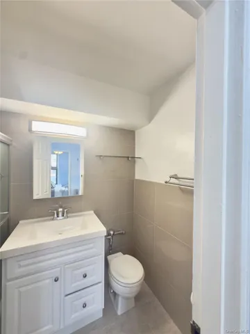 a bathroom with a toilet a sink a mirror and vanity