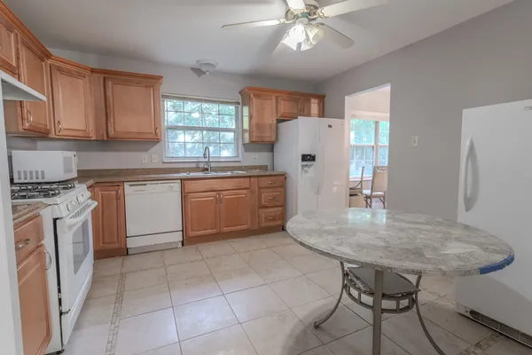 a kitchen with a table chairs refrigerator and cabinets