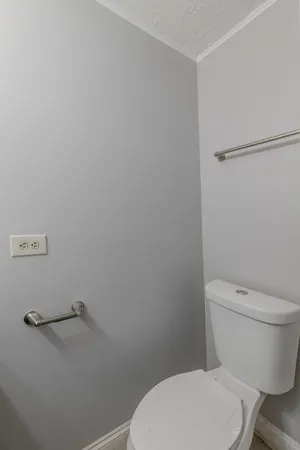 a white toilet sitting next to a shower