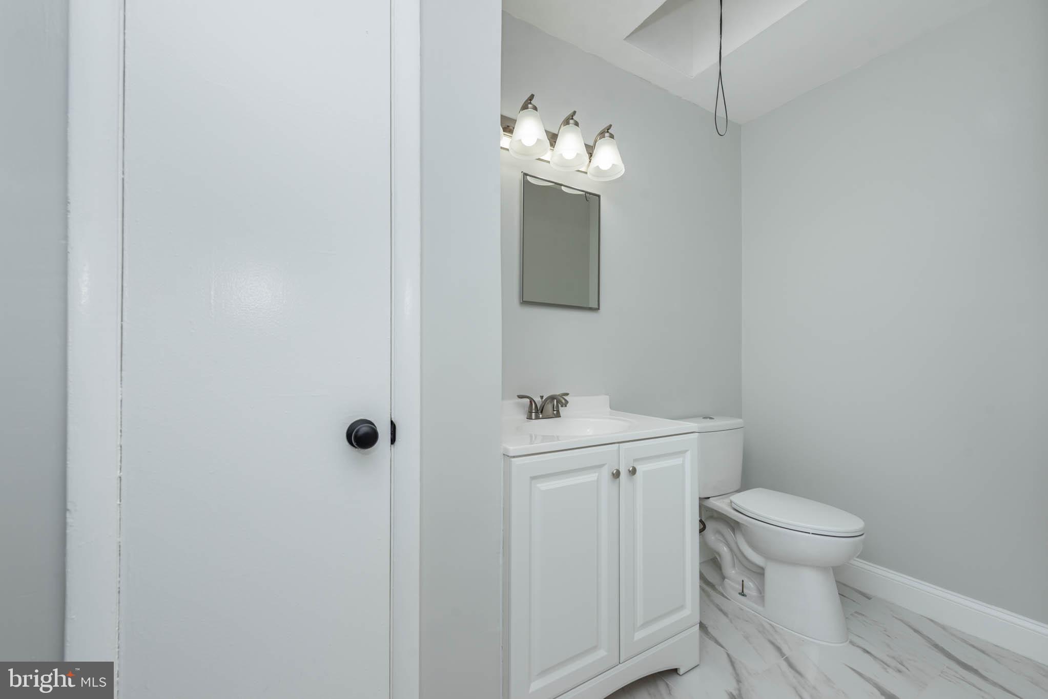 5611 Force Road Baltimore, MD 21206 - Photo 14 of 21 a bathroom with a toilet a sink and mirror