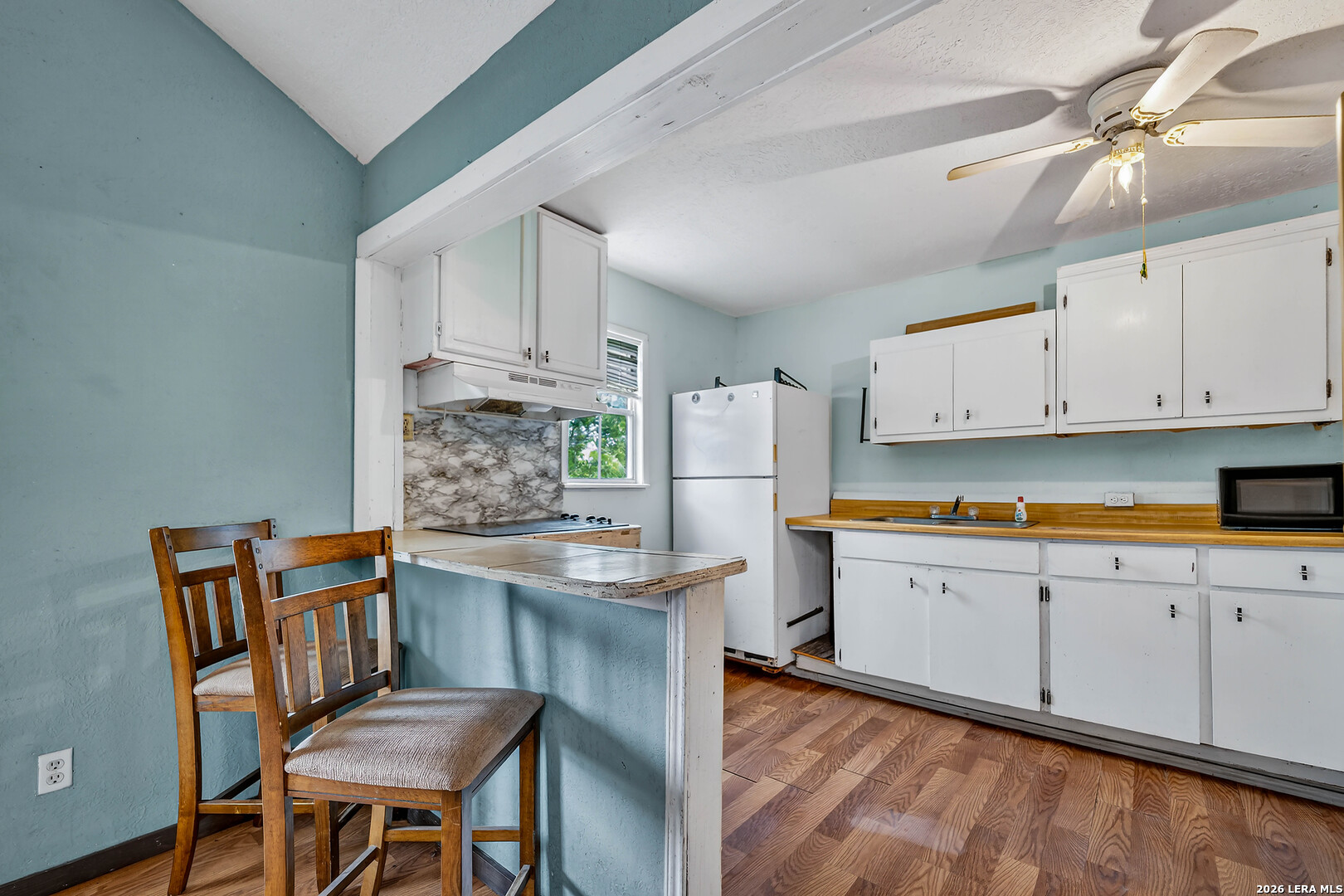903 East Westmeyer Street Poth, TX 78147 - Photo 15 of 23 a kitchen with granite countertop white cabinets and stainless steel appliances