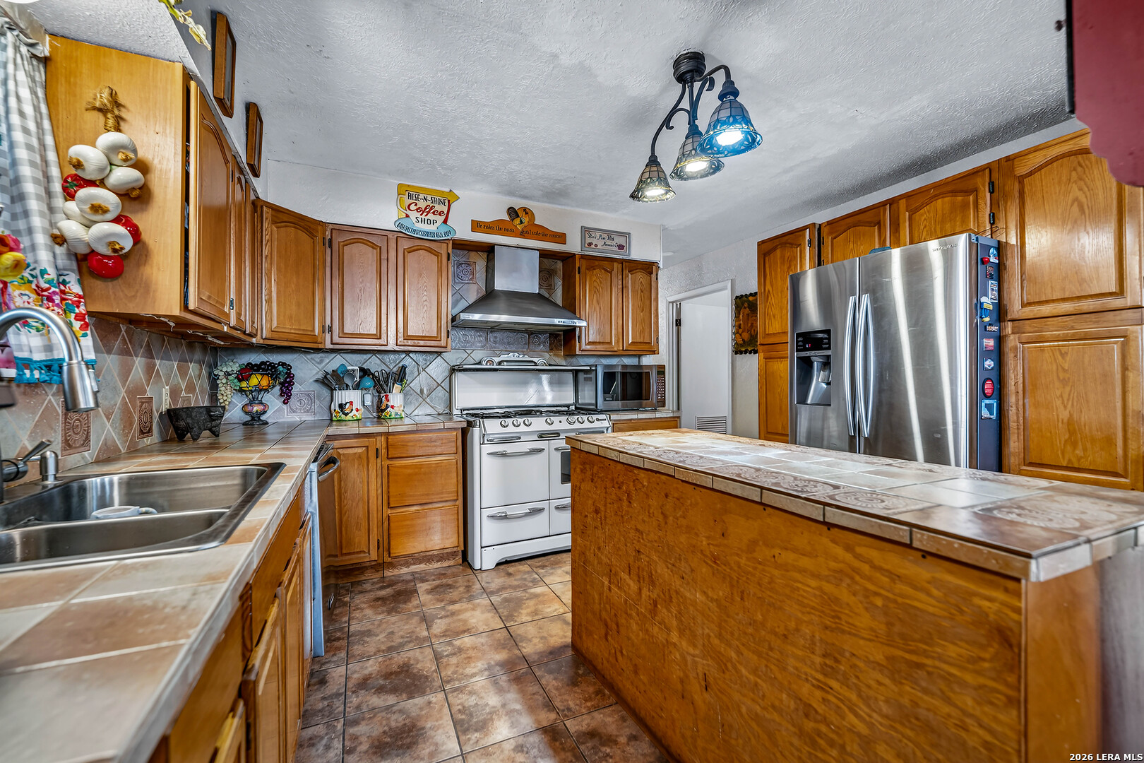 903 East Westmeyer Street Poth, TX 78147 - Photo 7 of 23 a kitchen with stainless steel appliances granite countertop a sink stove and refrigerator