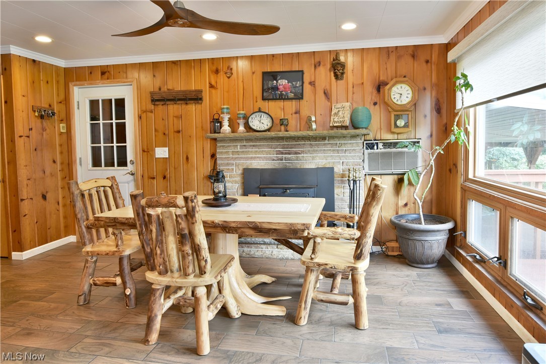 1711 Salt Springs Road Mineral Ridge, OH 44440 - Photo 10 of 35 Dining area featuring wood burner, ornamental molding, ceramic hardwood look floors, and ceiling fan