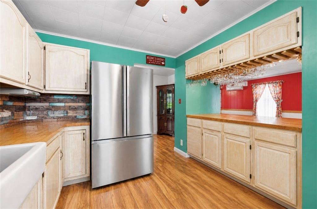 331 Hill Road Georgetown, PA 15043 - Photo 8 of 33 a kitchen with granite countertop a refrigerator a sink dishwasher a stove and white cabinets with wooden floor