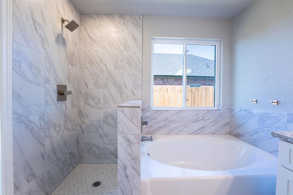 1020 Springview Lane Mabank, TX 75147 - Photo 8 of 15 Full bathroom featuring a bath, a marble finish shower, vanity, and a textured wall