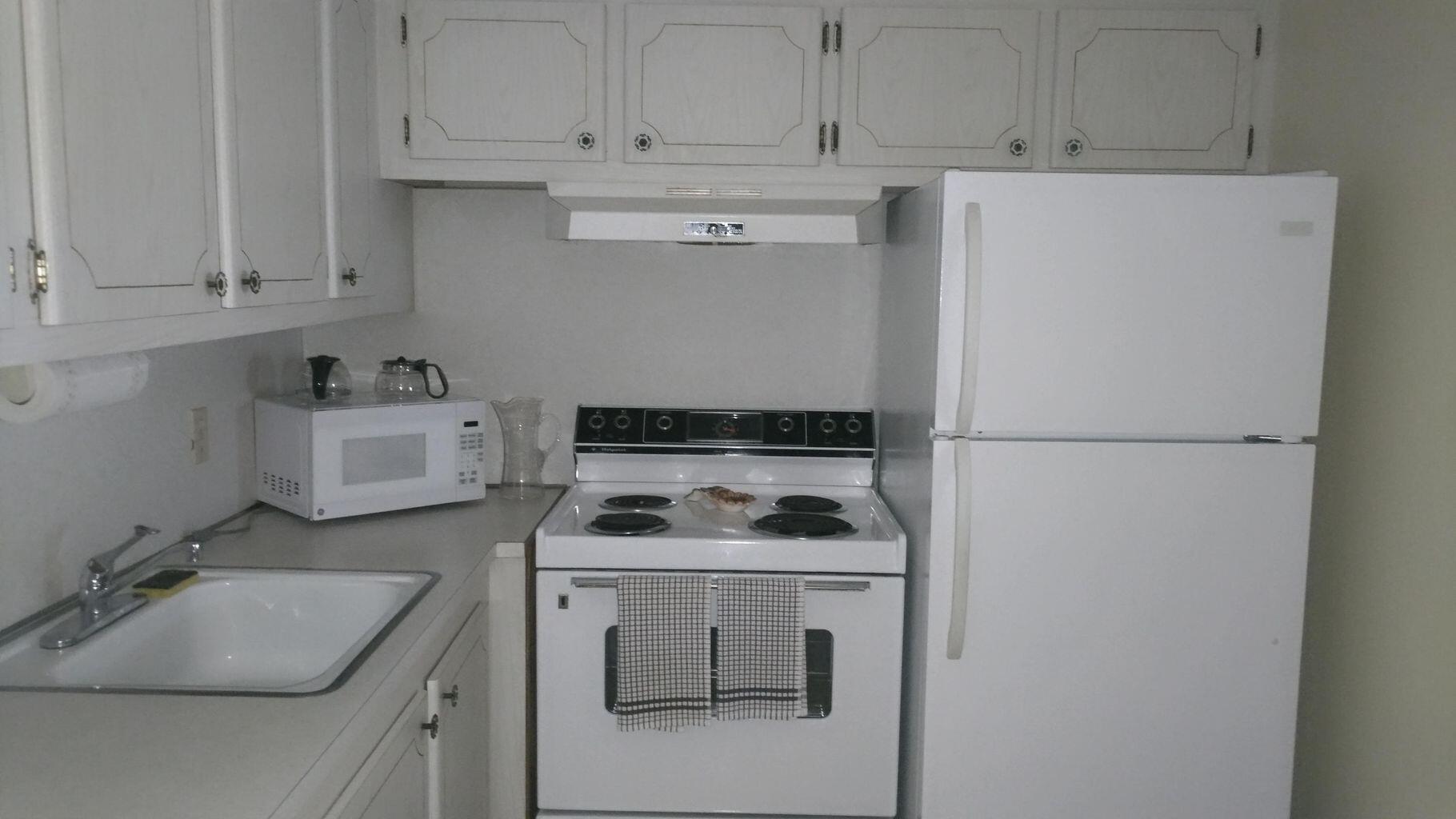 a kitchen with a white stove and white cabinets