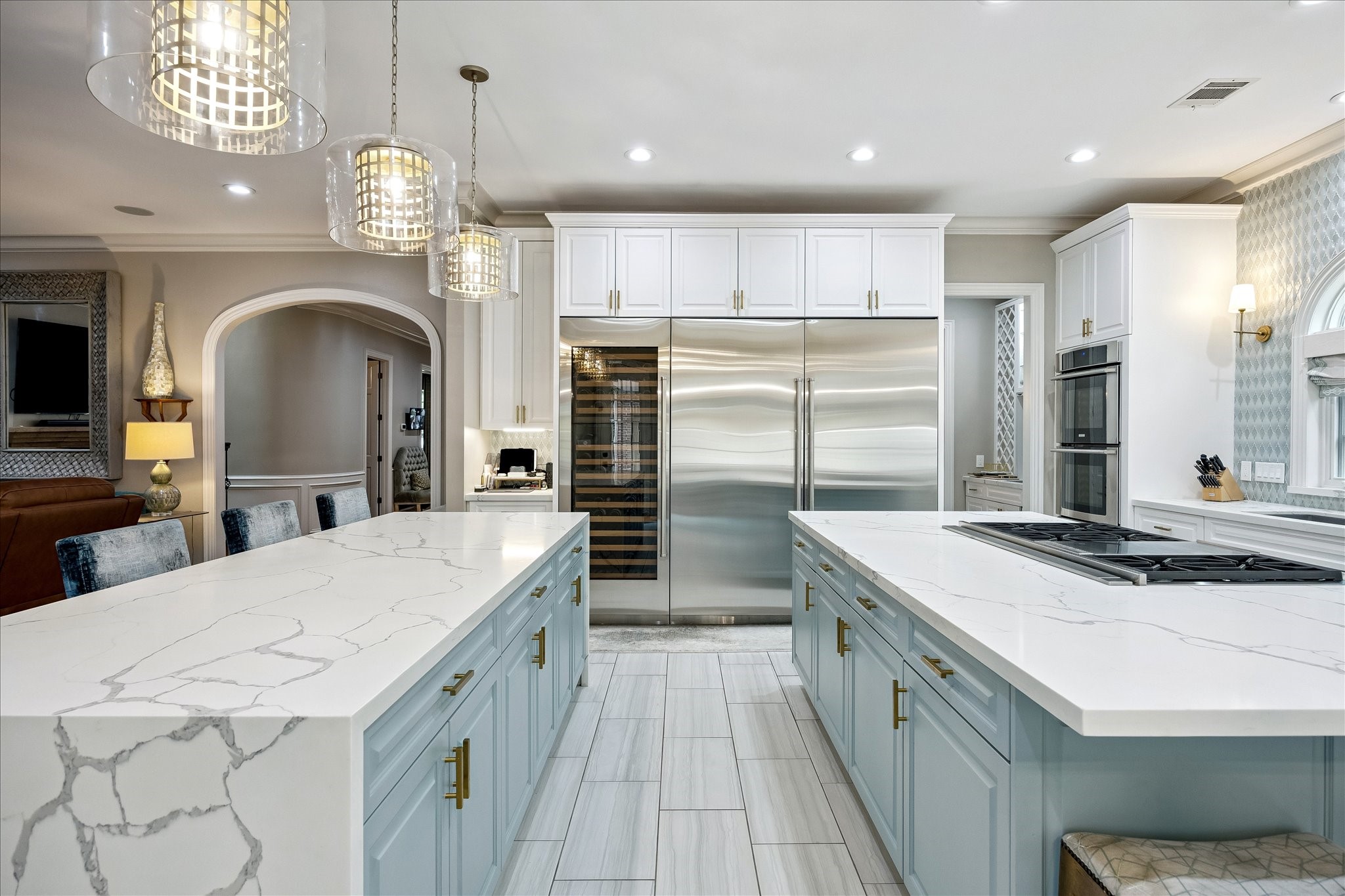 6358 Auden Street Houston, TX 77005 - Photo 14 of 50 a large kitchen with stainless steel appliances a large kitchen island a stove a refrigerator a sink dishwasher a dining table and chairs with wooden floor