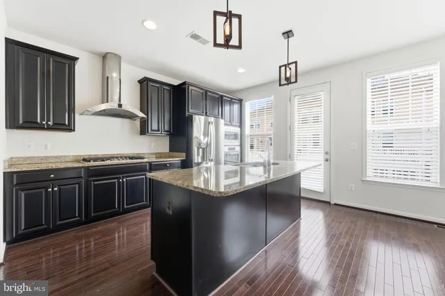 a kitchen with granite countertop a refrigerator and a stove