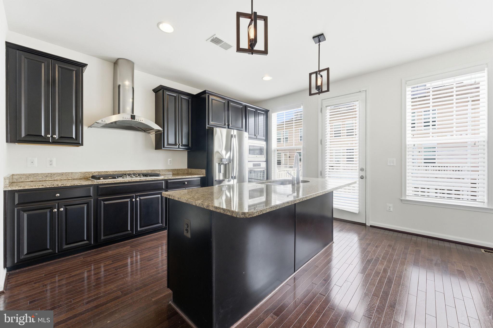 42396 Benfold Square Brambleton, VA 20148 - Photo 12 of 65 a kitchen with stainless steel appliances granite countertop a sink a stove and a wooden floors
