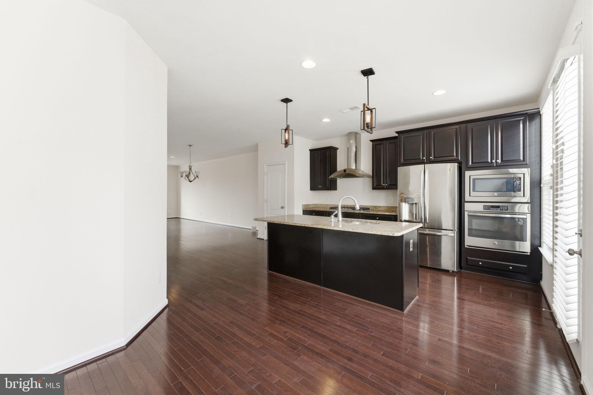 42396 Benfold Square Brambleton, VA 20148 - Photo 14 of 65 a kitchen with granite countertop a refrigerator and a stove