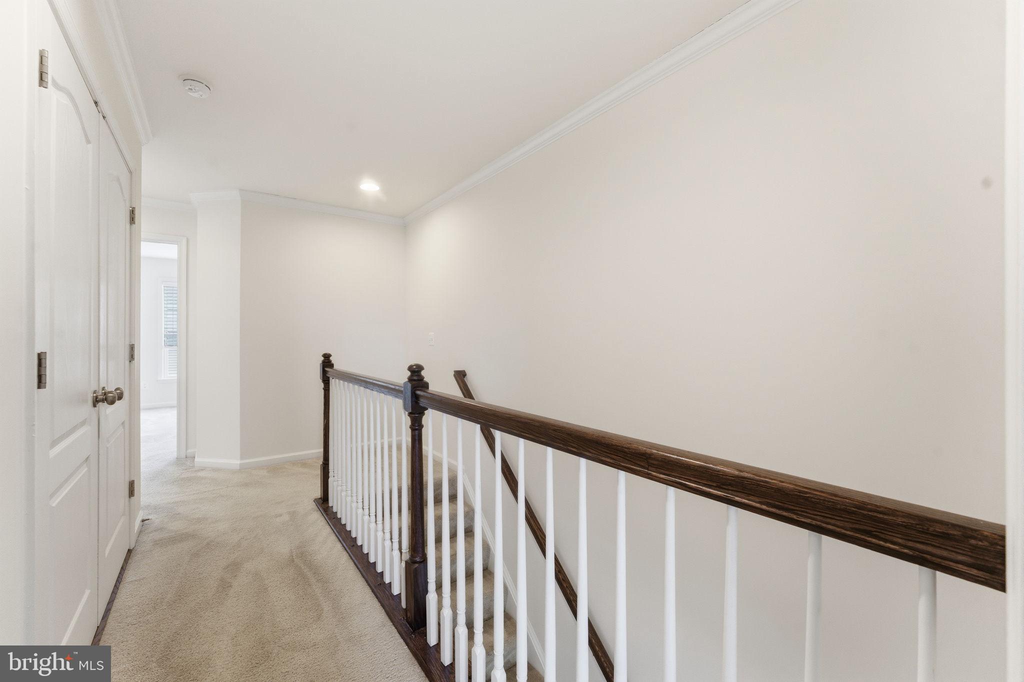42396 Benfold Square Brambleton, VA 20148 - Photo 22 of 65 a view of a hallway with wooden floor and staircase
