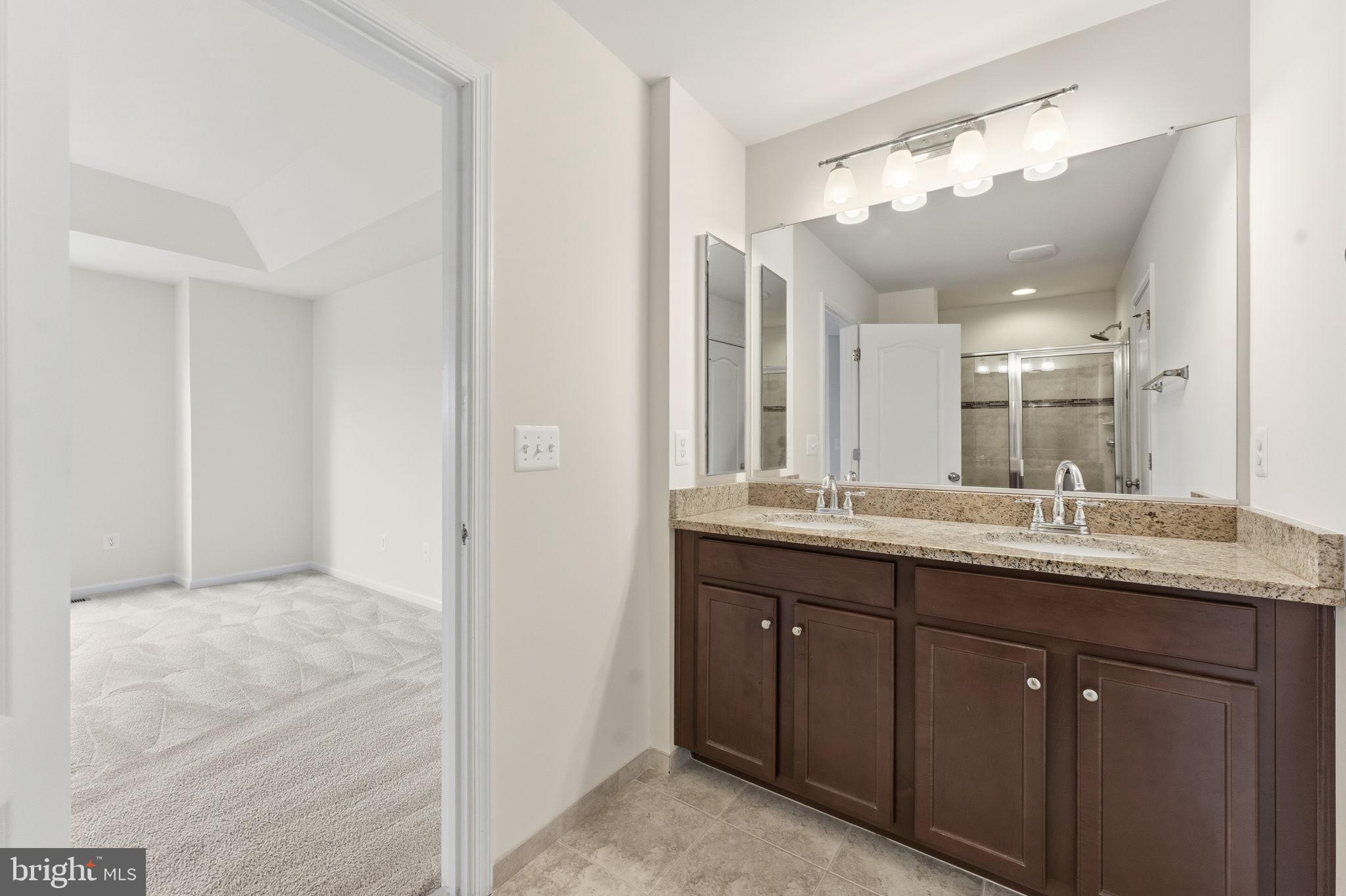 42396 Benfold Square Brambleton, VA 20148 - Photo 29 of 65 a bathroom with a granite countertop sink and a mirror