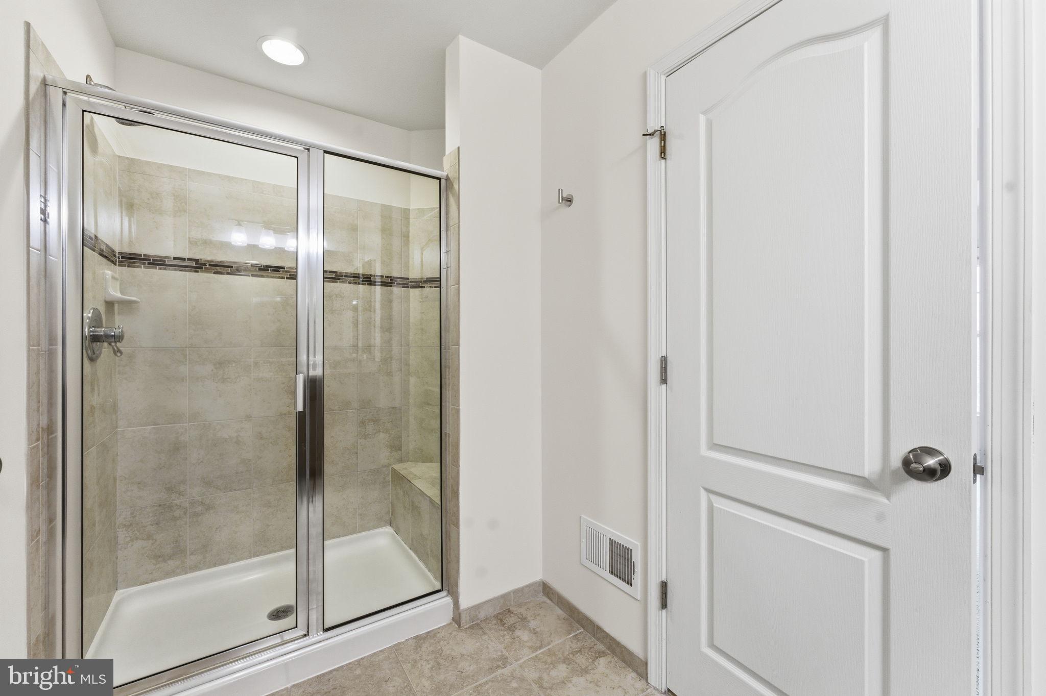 42396 Benfold Square Brambleton, VA 20148 - Photo 32 of 65 a bathroom with a glass shower door