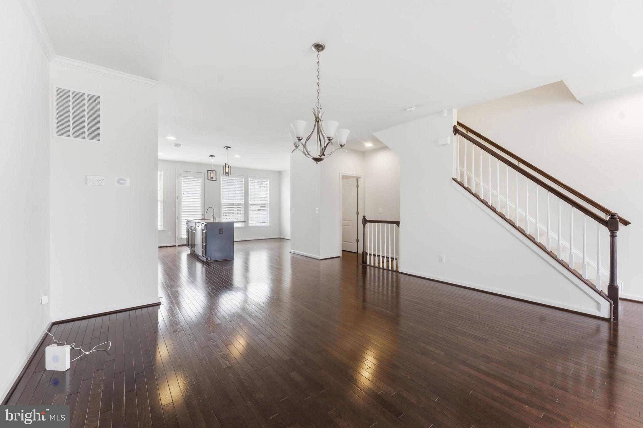 42396 Benfold Square Brambleton, VA 20148 - Photo 62 of 65 a view of a room with wooden floor staircase and a kitchen