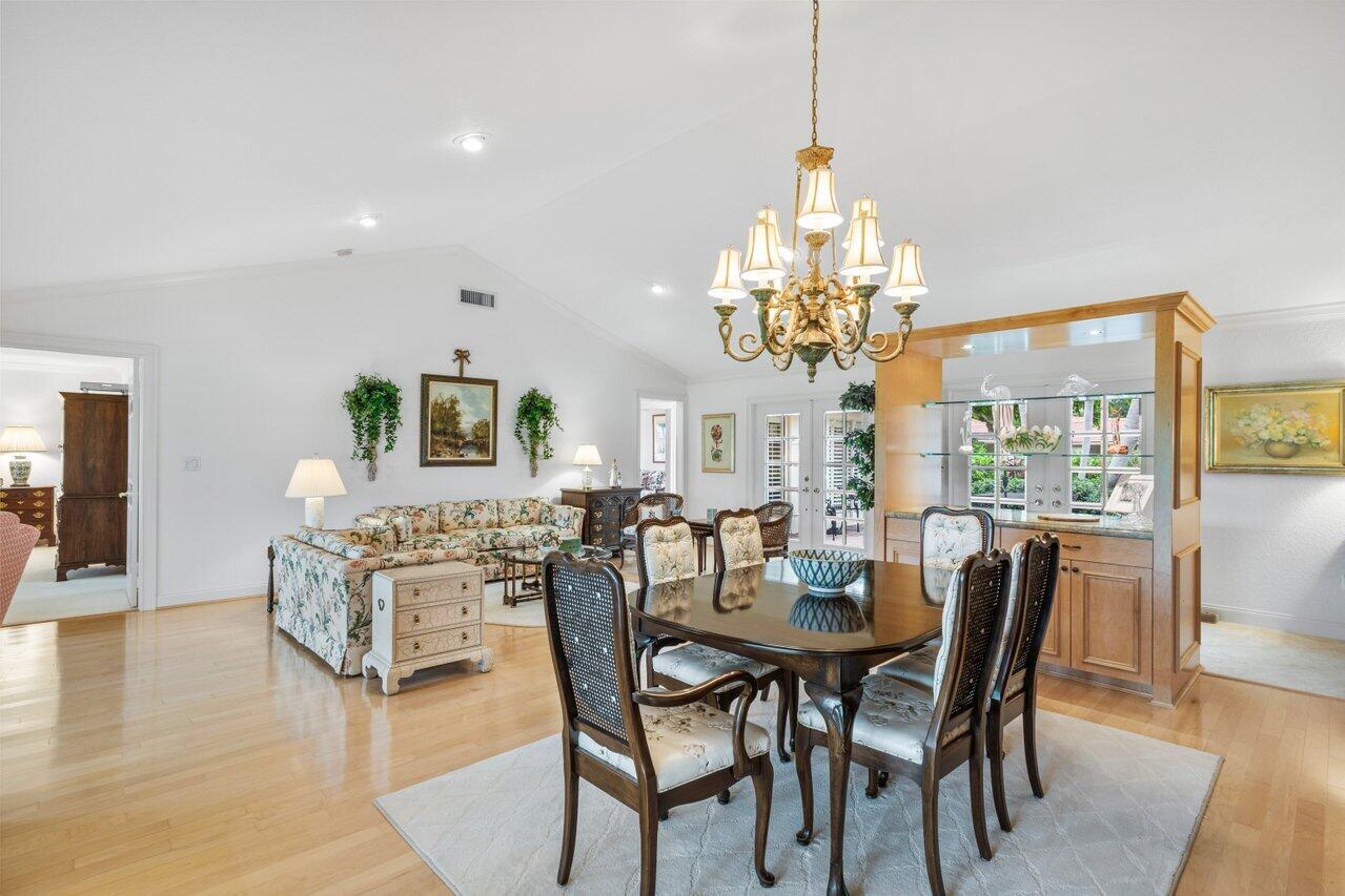 4024 Shelldrake Lane, Unit SHELLDRAKE Boynton Beach, FL 33436 - Photo 12 of 51 a dining room with furniture a chandelier and wooden floor
