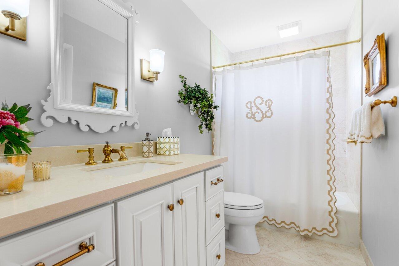 4024 Shelldrake Lane, Unit SHELLDRAKE Boynton Beach, FL 33436 - Photo 27 of 51 a bathroom with a granite countertop sink a toilet and a mirror