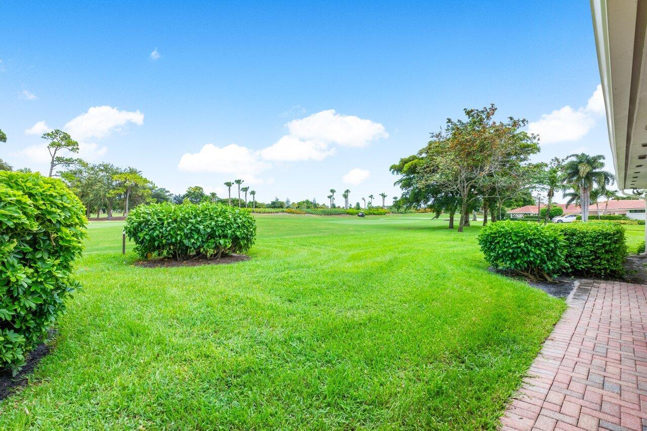 4024 Shelldrake Lane, Unit SHELLDRAKE Boynton Beach, FL 33436 - Photo 35 of 51 a view of a garden with a building in the background