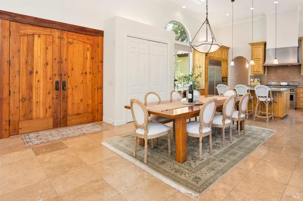 a dining room with furniture a large window and kitchen view