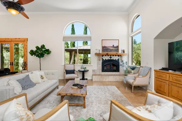 a living room with furniture a fireplace and a large window