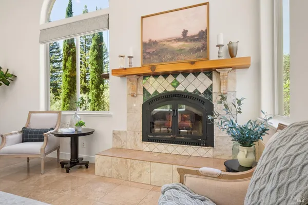 a living room with furniture a fireplace and a large window