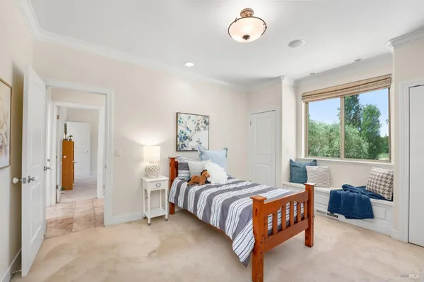a bedroom with a bed and painting on the wall