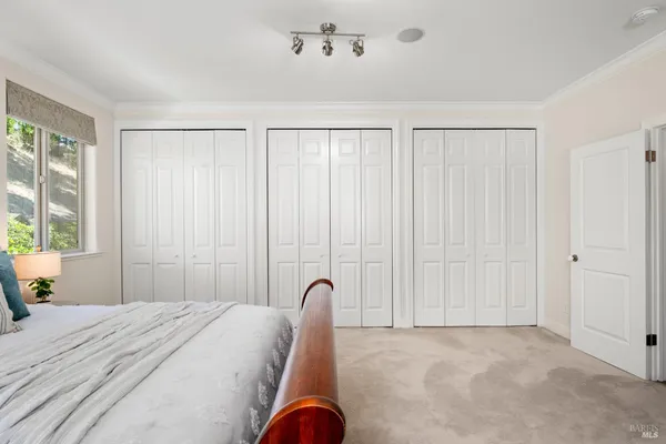 a spacious bedroom with a large bed and a chandelier