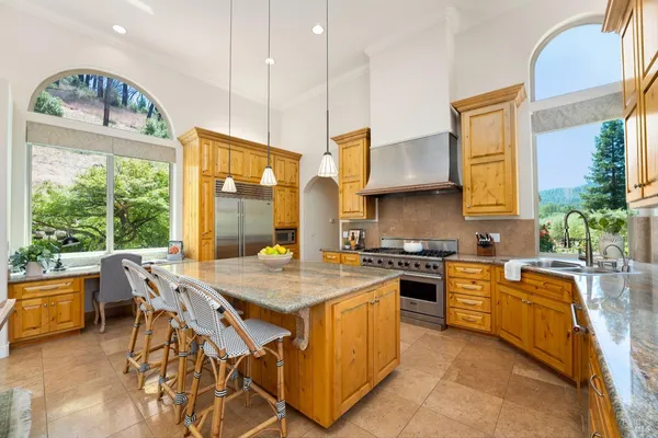 a very nice looking dining room with a large window and kitchen view