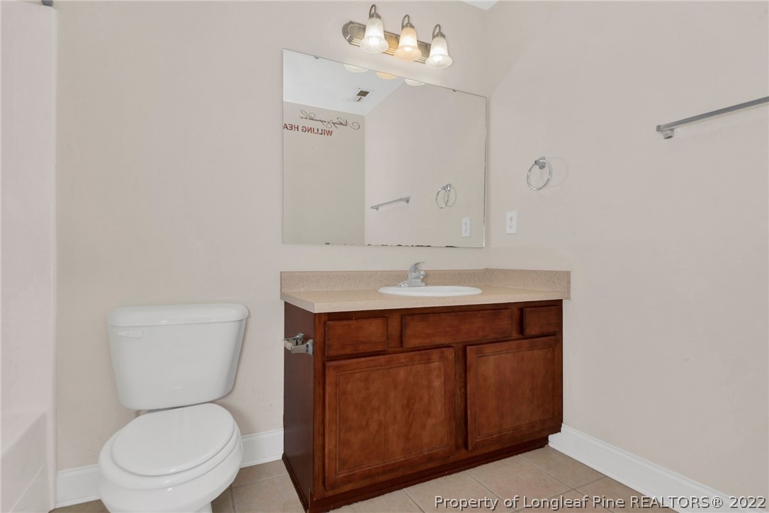 1623 Silver Ridge Court Fayetteville, NC 28304 - Photo 23 of 34 a bathroom with a toilet a sink a mirror and vanity