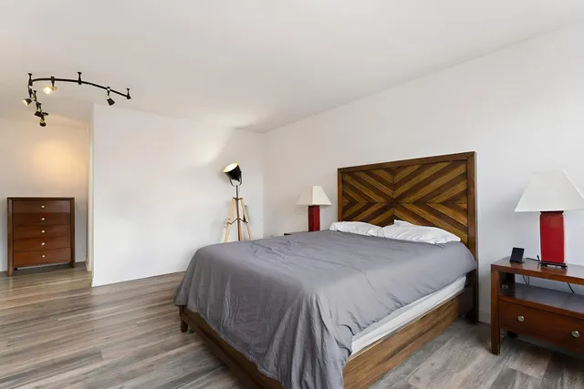 a bedroom with a bed and wooden floor