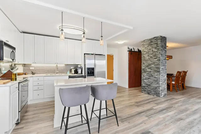 a kitchen with a table chairs refrigerator and cabinets