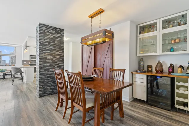 a dining room with furniture a chandelier and wooden floor